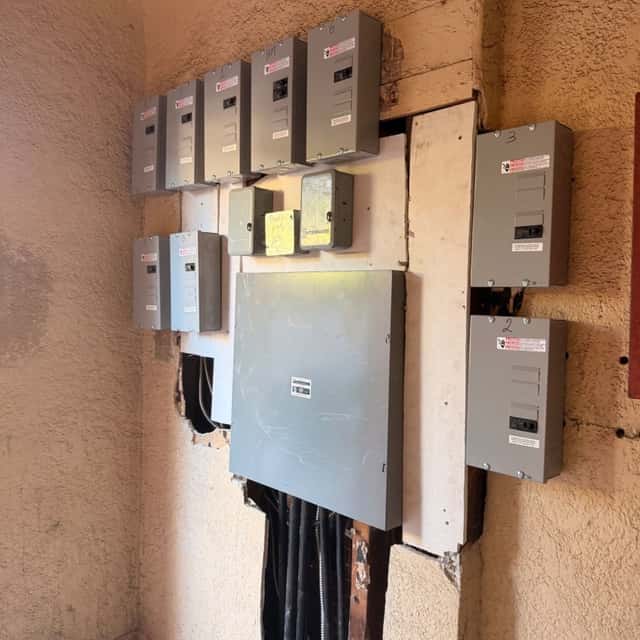 Multi-gang electric meter bank and main service panel on a stucco wall — Nebady's Electric Corporation, Palmdale, CA